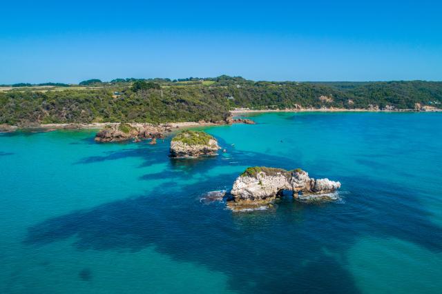Eroding rocky outcrops in shallow turquoise ocean water at Walkerville, Victoria, Australia - aerial view