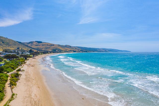 People are enjoying a sunny day on a beach at Apollo Bay, Australia